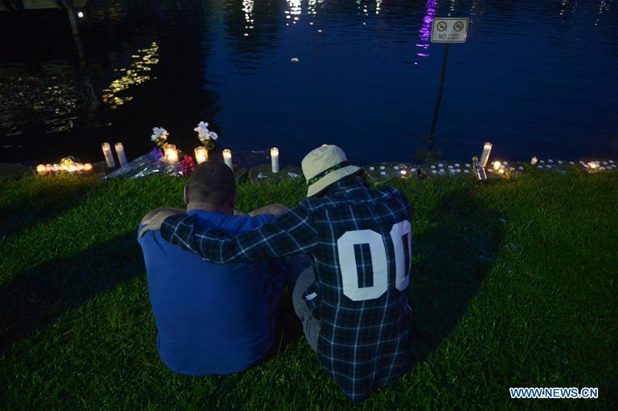 People mourn the victims of the mass shooting during a vigil at a park in Orlando, the United States, on June 12, 2016.