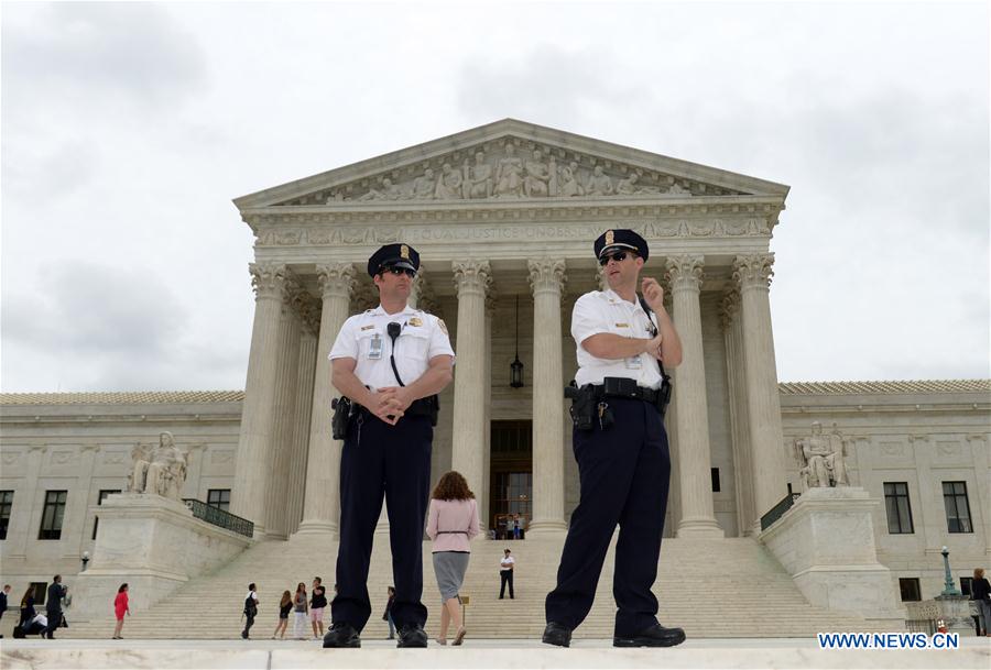 Policemen guard near an immigration rally outside the Supreme Court in Washington D.C., the United States, on June 23, 2016.
