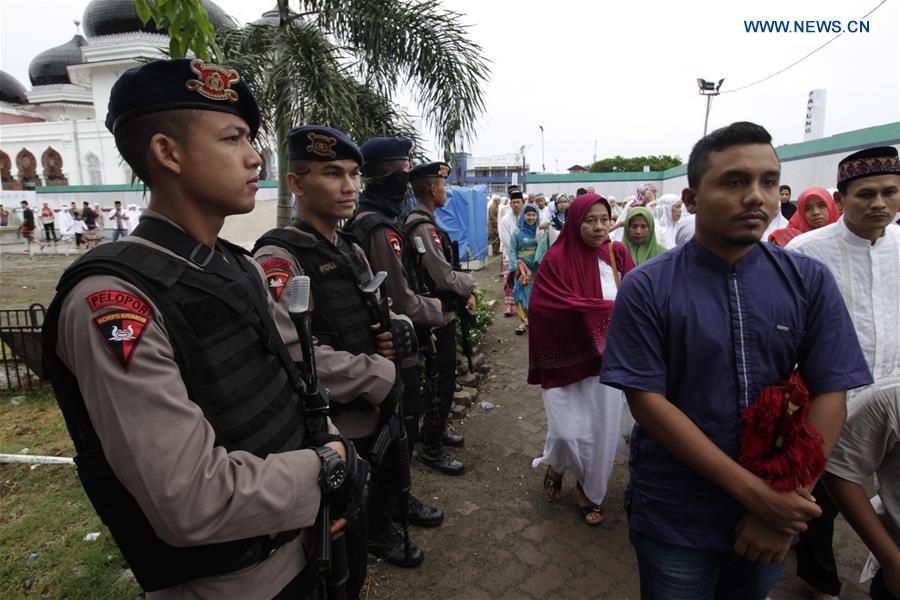 Indonesian police officers stand guard after Muslims perform Eid al-Fitr praying in Aceh, Indonesia, July 6, 2016. 