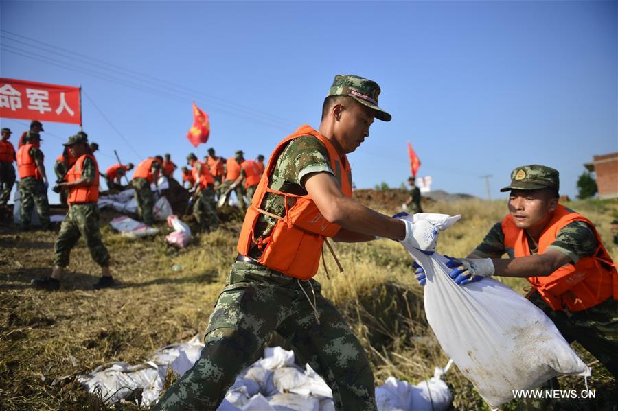 Armed police use sandbags to reinforce the dike of the Yangtze River at Jiangxinzhou section for flood control, in Jiujiang County, east China's Jiangxi Province, July 8, 2016.