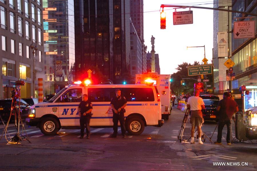 A man tossed a hoax explosive into a marked police car in midtown Manhattan on Wednesday night and was taken into custody at Columbus Circle on Thursday morning.