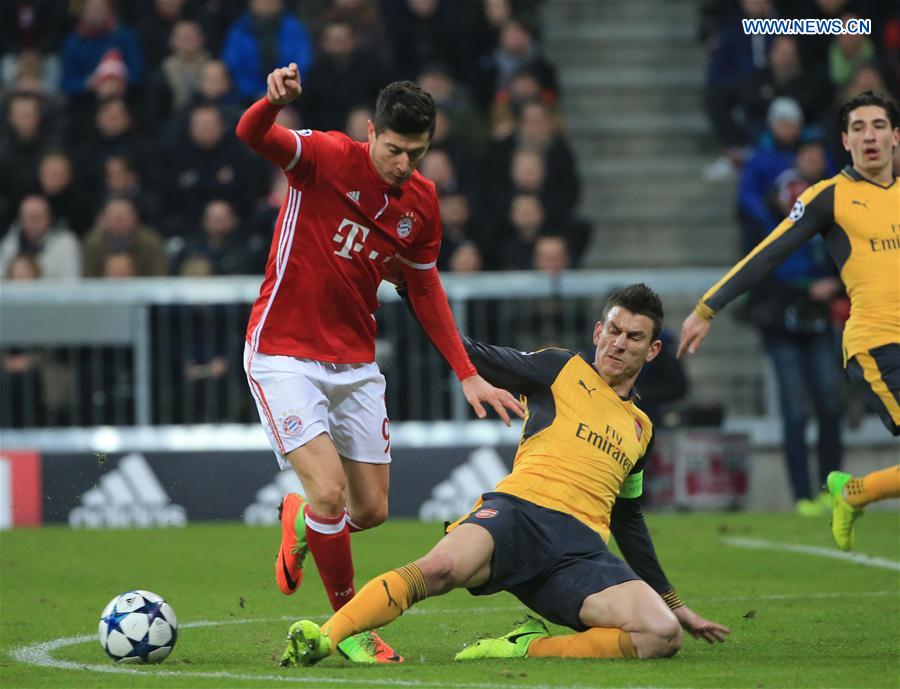 Arsenal's Laurent Koscielny (R) vies with Bayern Munich's Robert Lewandowski during the first leg match of Round of 16 of European Champions League between Bayern Munich and Arsenal in Munich, Germany, on Feb. 15, 2017. 