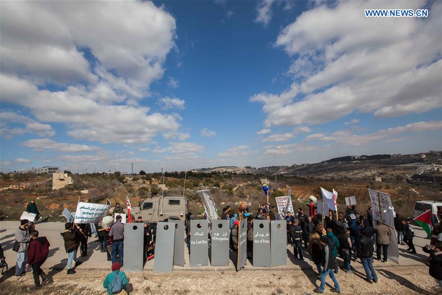 Israeli and Palestinian members of the 'Combatants For Peace' association hold placards representing Israel's controversial separation barrier during a protest against the Israeli barrier near the West Bank city of Bethlehem, on Feb. 17, 2017.