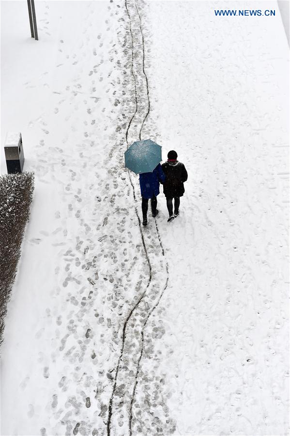 People walk in snow in Taiyuan, capital of north China's Shanxi Province, Feb. 21, 2017.