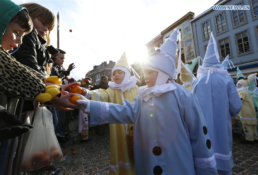 Children march and distribute oranges symbolizing the coming Spring to visitors, in Binche, Belgium, on Feb. 28, 2017. 