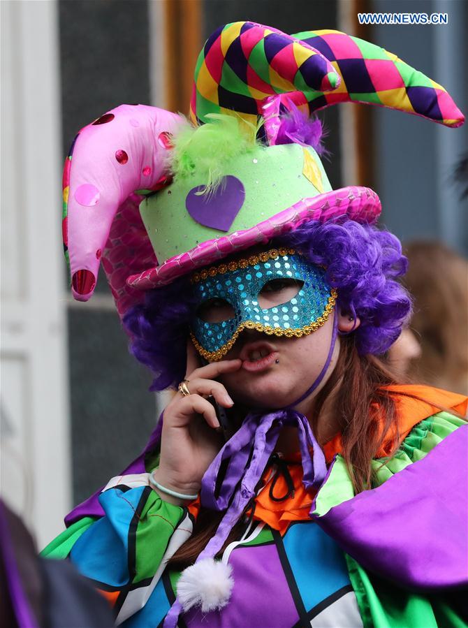 A woman talks on the cellphone during the mask carnival in Brussels, Belgium, March 4, 2017. 