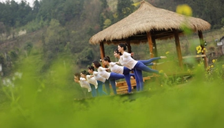 Yoga fans practise yoga on farmland of flowers in C China's Zhangjiajie