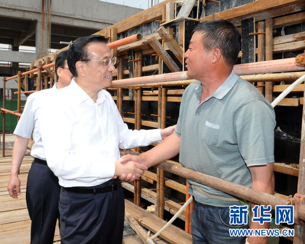 這是5月22日，李克強在德潤污水處理廠考察在建污水處理工程時，與農民工交談。 新華社記者謝環馳攝