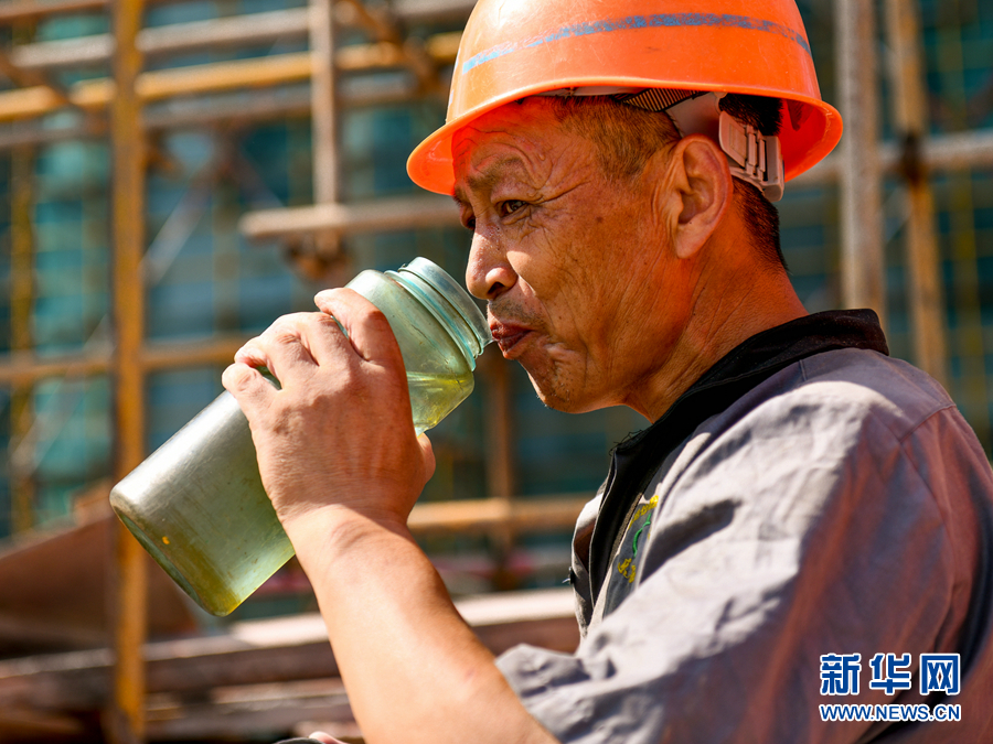 7月14日,和县一处建筑工地中的工人在工作间隙喝水.