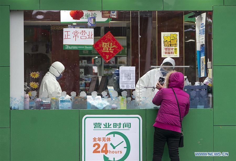 Seorang wanita mendatangi apotek di Wuhan untuk membeli obat, Minggu (26/1/2020).