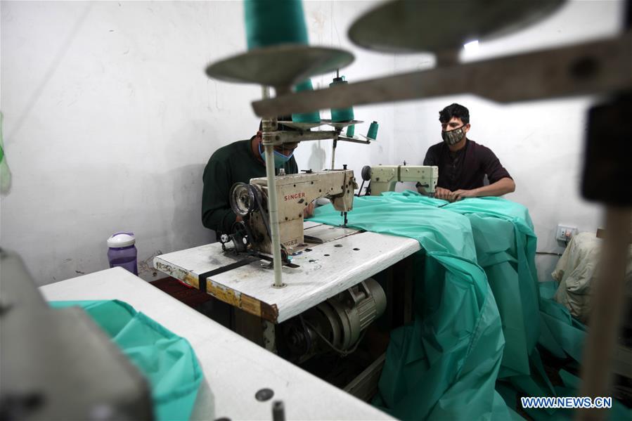 workers make protective suits amid covid-19 outbreak in peshawar