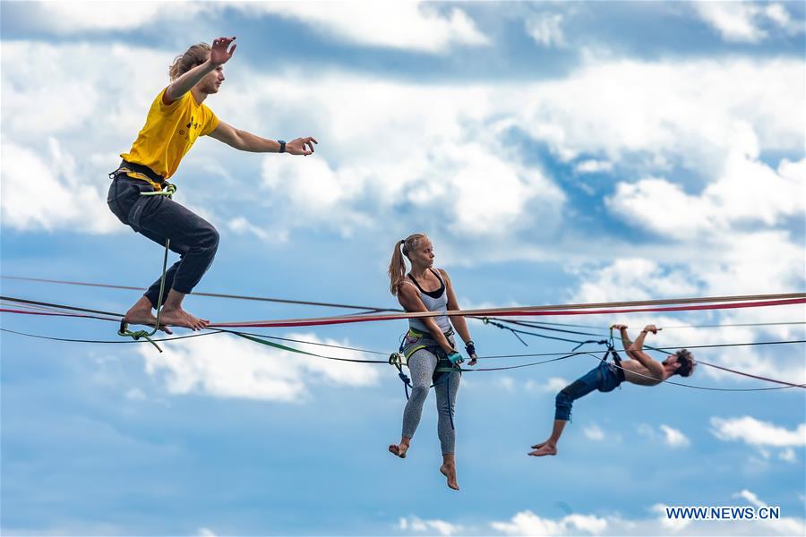 People practise rope-walking above Gortanova Bay in Pula, Croatia - Xinhua
