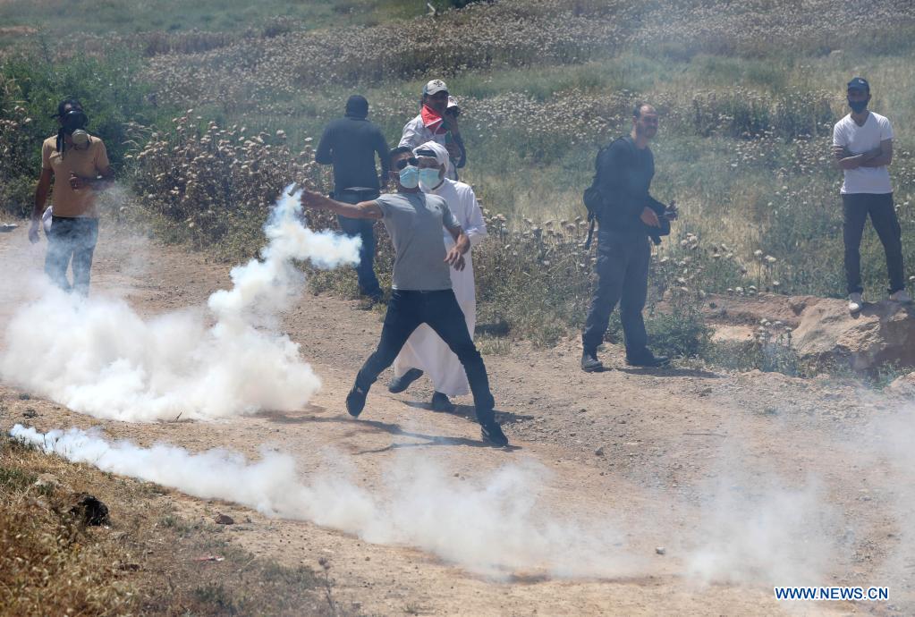 Palestinian Protester Throws Back Tear Gas Canister In West Bank