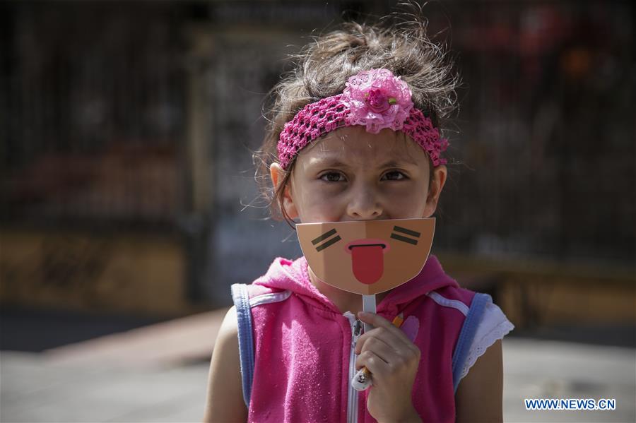  A girl poses with a mask during the campaign 'Stick your Tongue Out to Child Labour' on the World Day against Child Labour in Bogota, Colombia, on June 12, 2016.