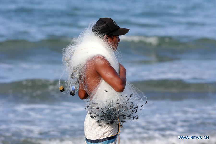 A fisherman uses a net to catch fish in Aurora Province, the Philippines, June 17, 2016.