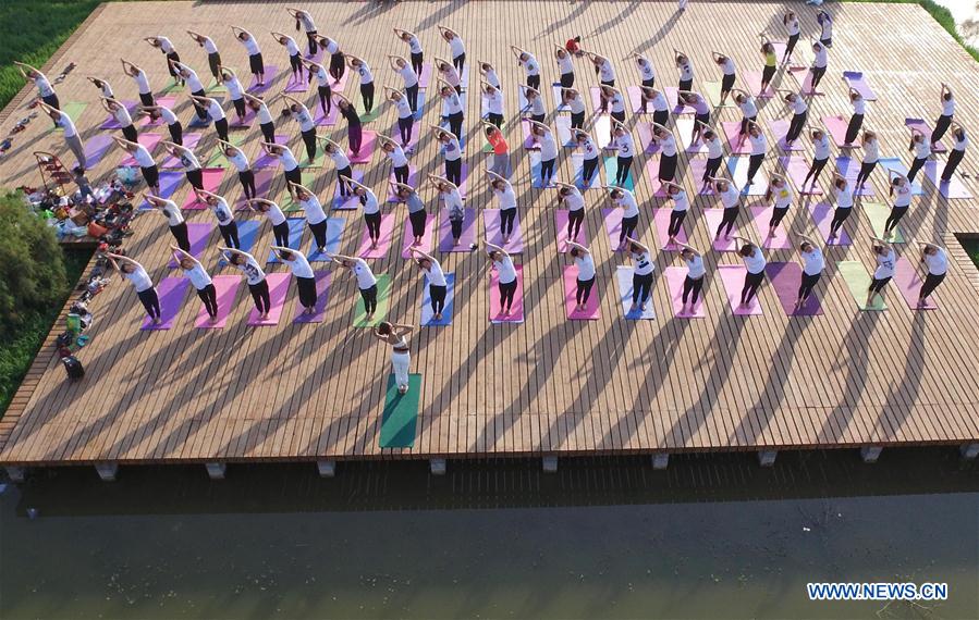 People practise yoga at the Longquan Lake Park in Wuzhi County of Jiaozuo, central China's Henan Province, June 18, 2016.