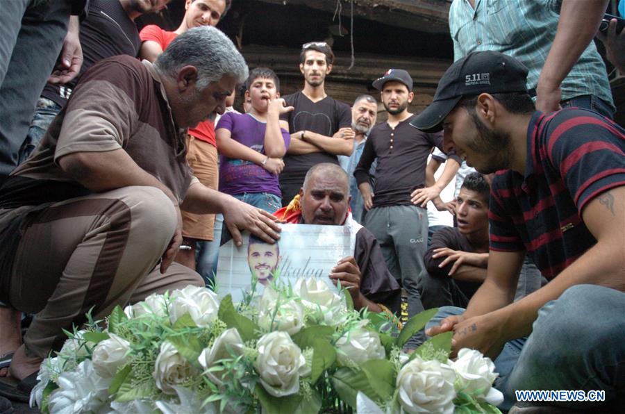 People carry a coffin as they mourn for the victims killed in Sunday's car bombing attacks in Karrada-Dakhil district in southern Baghdad, Iraq, on July 5, 2016.
