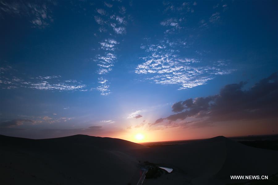 The scene of sunset is seen at the Singing Sand Dune in Dunhuang, northwest China's Gansu Province, July 11, 2016.