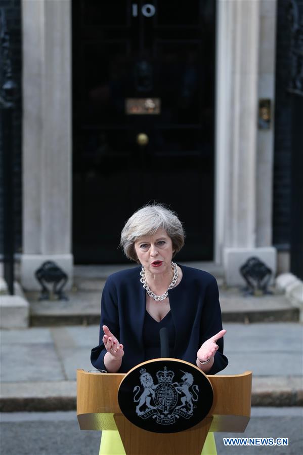 Britain's new Prime Minister Theresa May(L) and her husband pose for photos in front of 10 Downing Street in London, Britain on July 13, 2016.