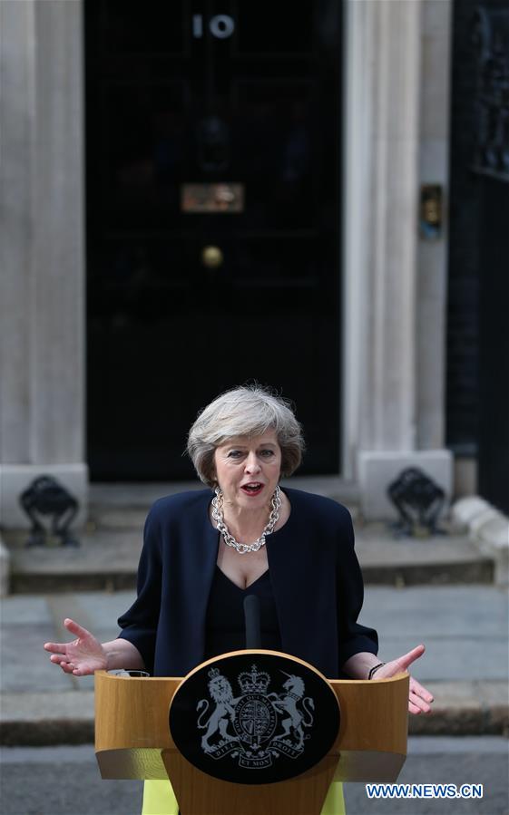 Britain's new Prime Minister Theresa May(L) and her husband pose for photos in front of 10 Downing Street in London, Britain on July 13, 2016.