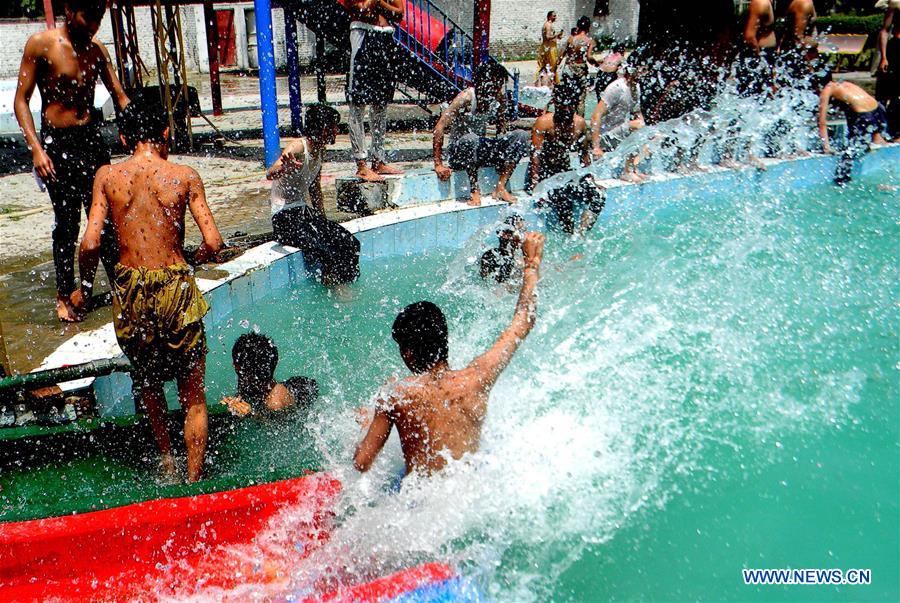 Boys cool themselves off in a swimming pool in northwest Pakistan's Peshawar, on Aug. 5, 2016. 