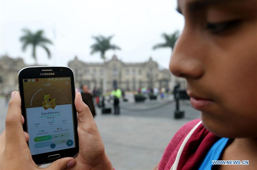 Two youngsters play 'Pokemon Go' on their smartphones at Plaza Mayor in Lima, capital of Peru, on Aug. 7, 2016.