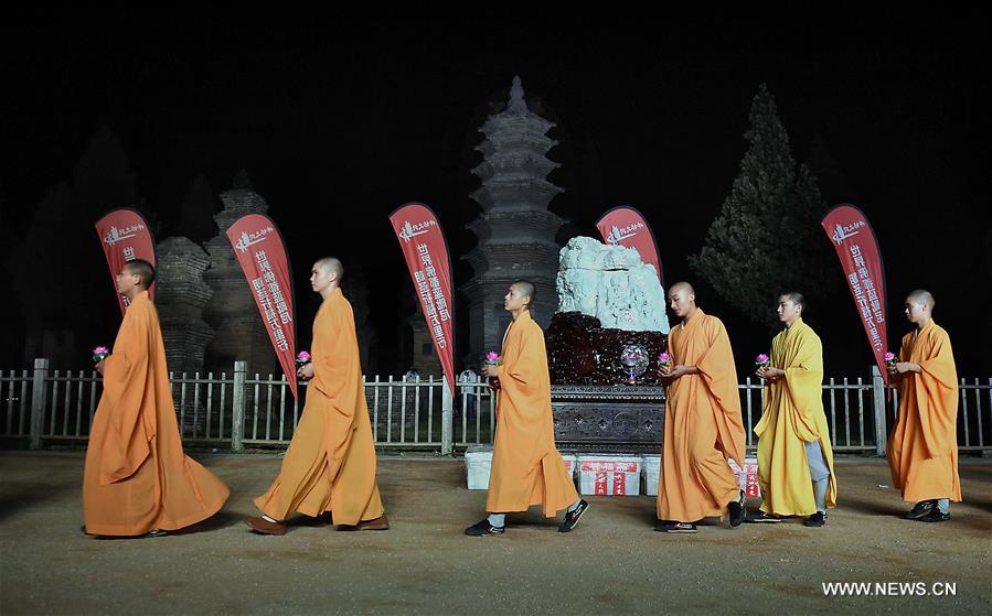 Monks carrying lotus-pattern lamps attend a buddhist ritual at the Shaolin Temple on the Songshan Mountain in Dengfeng City, central China's Henan Province, Aug. 13, 2016.
