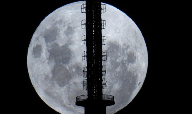 Moon rises behind Telstra Telecom Tower in Canberra, Australia