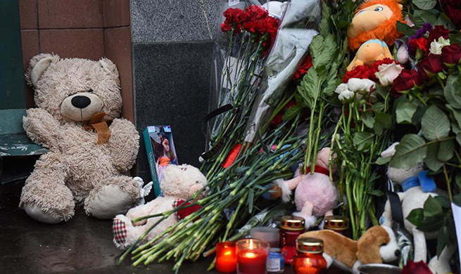 Flowers and dolls placed to mourn victims of Russia's shopping mall fire