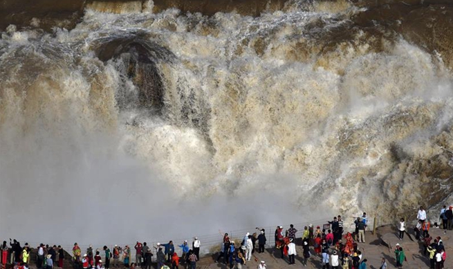 People enjoy scenery at Hukou Waterfall in China's Shanxi