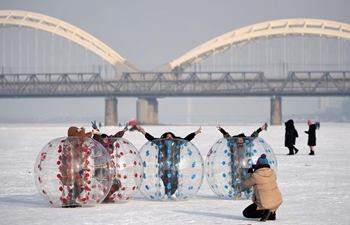 Tourists play on frozen Songhua River in NE China's Harbin