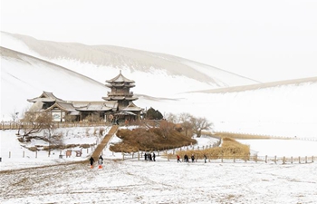 Scenery of snow-covered Crescent spring and Mingsha Mountain