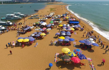 Tourists play at Yudai Beach scenic area in Boao, south China