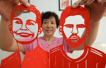 Craftswoman makes paper-cutting works to greet World Cup