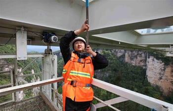 Female cleaner overcomes fear for cleaning bridge bottom in Zhangjiajie scenic spot, China's Hunan