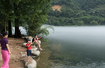 People enjoy coolness by Xin'an River in Jiande, E China's Zhejiang