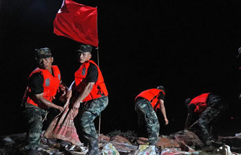 Armed police reinforce embankment in Poyang County, E China