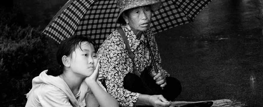 《雨中，帮奶奶卖菜的小姑娘》 张宝民/摄