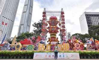 游客在香港中环一座庆祝香港回归20周年主题花灯前留影