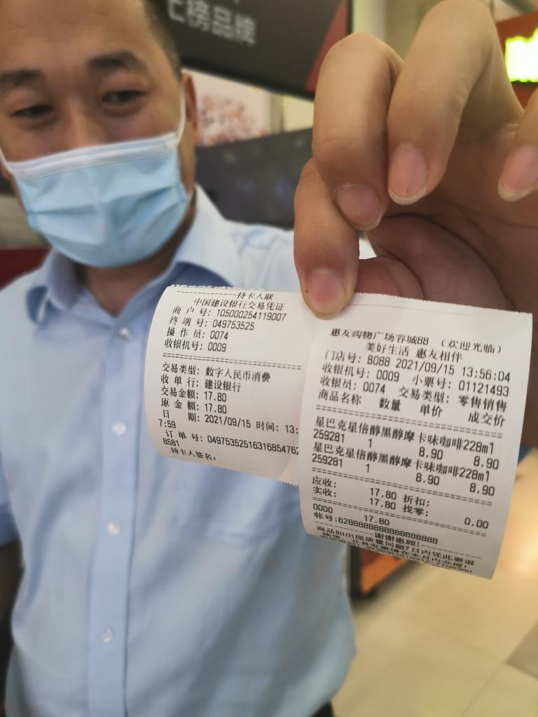 吴从涛展示购买两瓶咖啡的结账小票(新华社记者 王民摄)