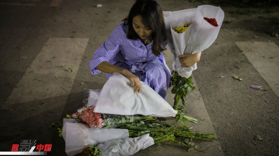 采购的鲜花太多,走出市场时不断从手中滑落,王黎媛将花放在地上,一束