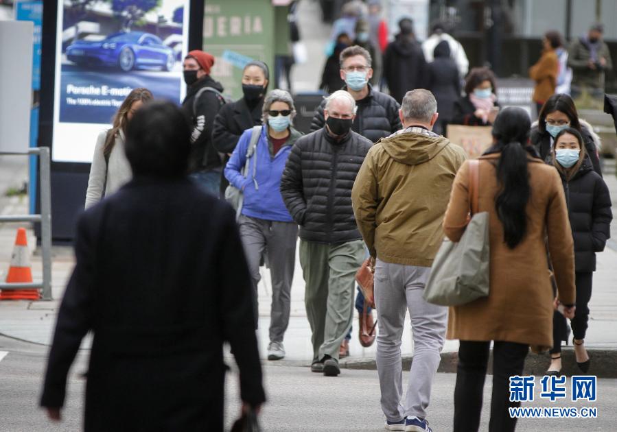 2月5日,戴口罩的行人走在加拿大温哥华街头.