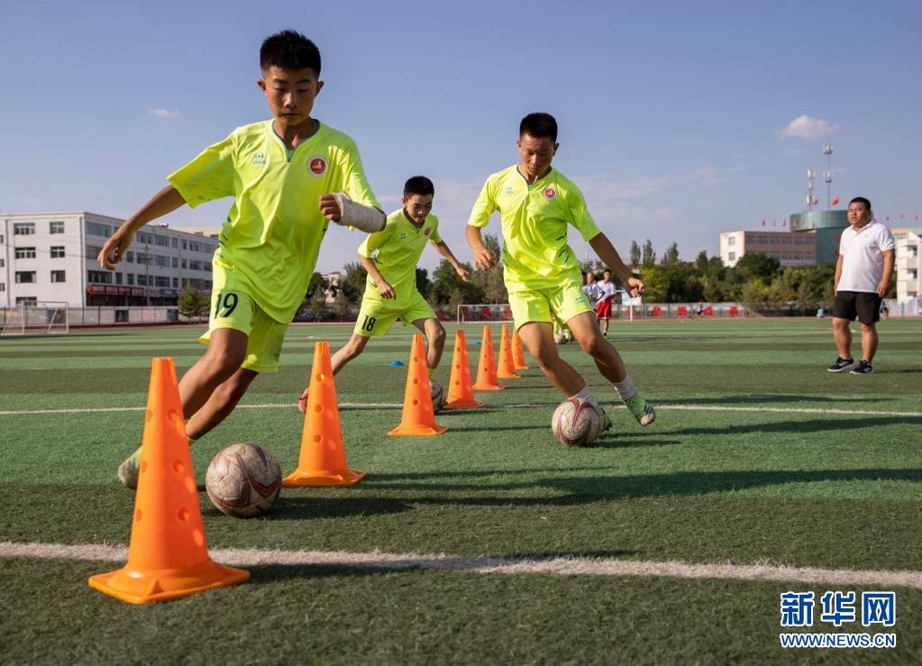 学生在宁夏盐池县第一中学运动场进行足球训练(7月15日摄).