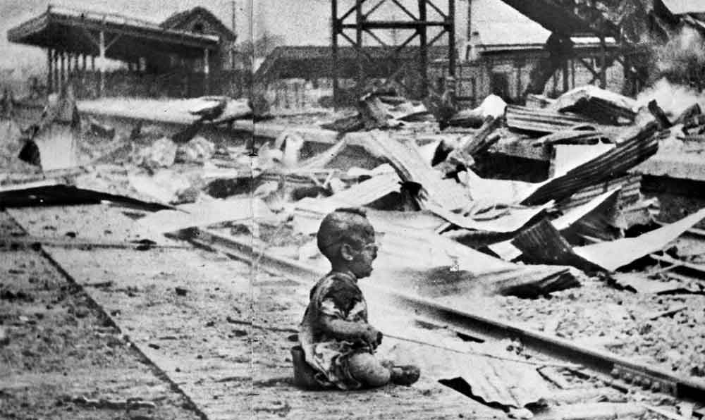1937年8月28日正午，日军轰炸上海南站，炸死正在候车的妇孺二百余名，伤者不计其数。这是炸后不久，图中一个满身是血的幼儿在剧痛和惊恐中嚎啕大哭。