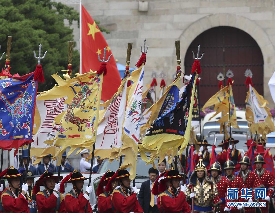 7月3日，韩国总统朴槿惠在青瓦台总统府举行隆重仪式，欢迎中国国家主席习近平对韩国进行国事访问。这是习近平的车队在身着民族服装的韩国礼仪队伍引导下驶入青瓦台。新华社记者丁林摄  