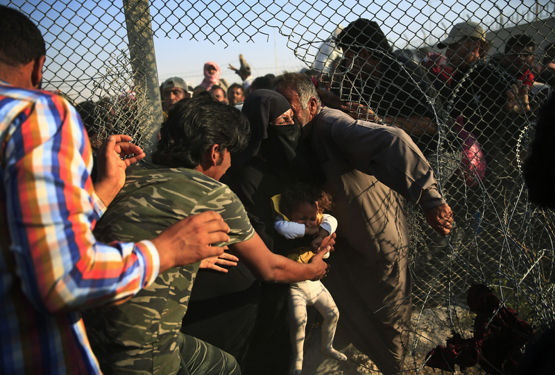 叙利亚难民撕破边境铁丝网涌入土耳其避难高清组图